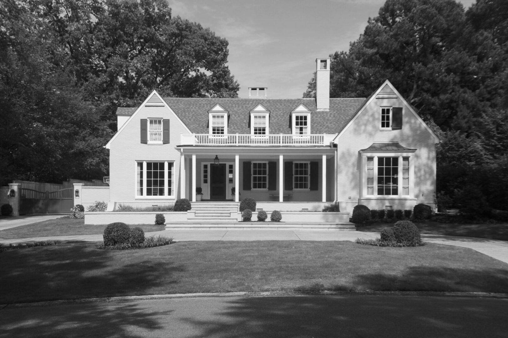 A large white house with a porch and two windows.