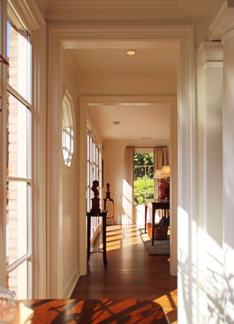 A hallway with many windows and wooden floors.