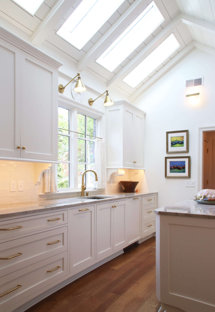 A kitchen with white cabinets and a sink.