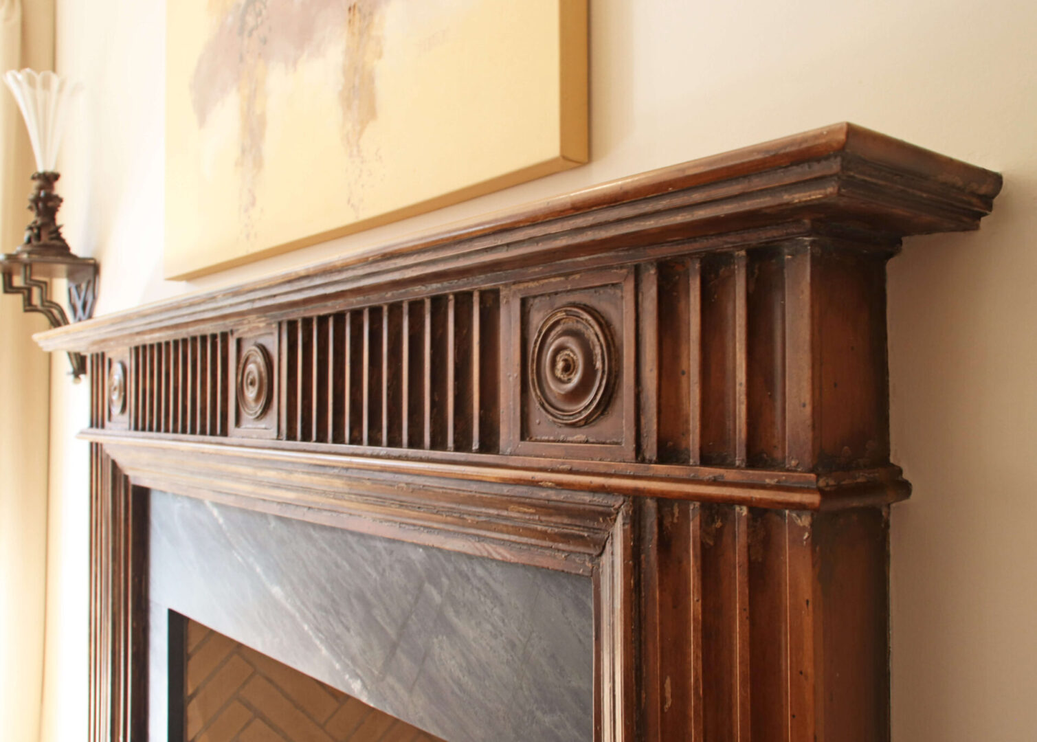 A fireplace mantle with wood carvings on it.