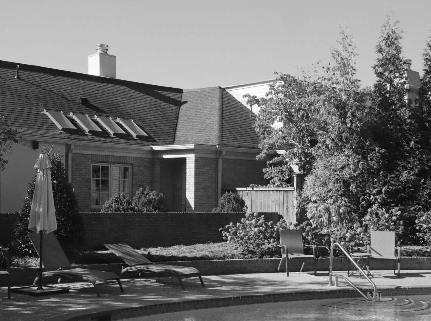 A black and white photo of an outdoor pool.