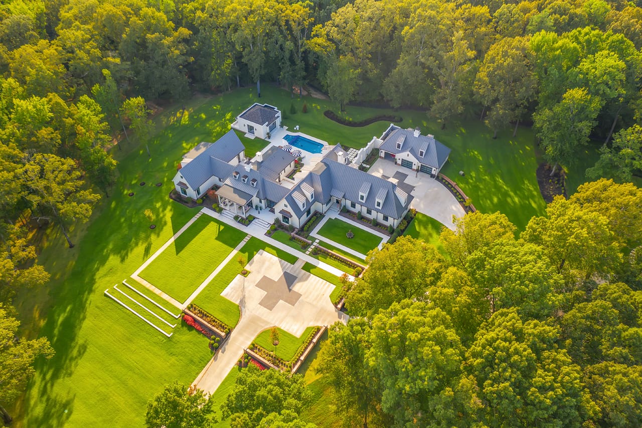 A large house in the middle of a green field.