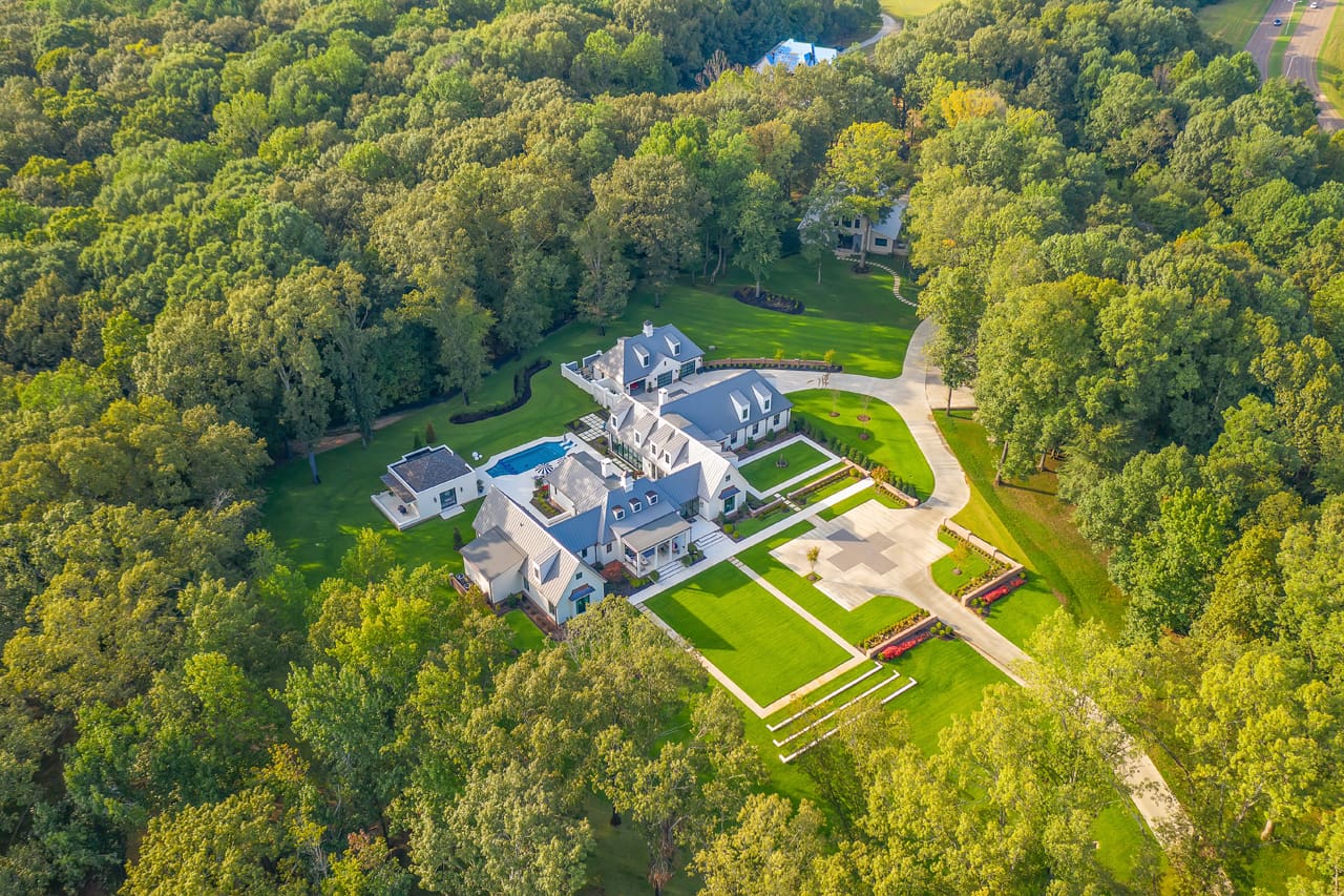 A large mansion surrounded by trees and grass.