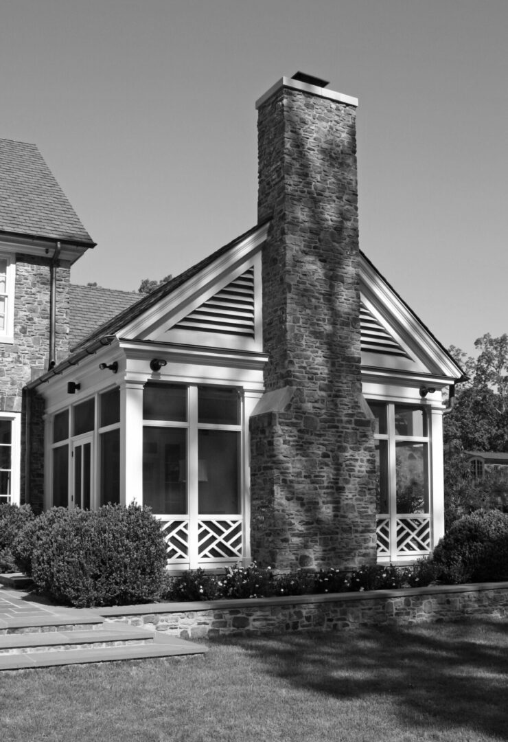 A black and white photo of a house with a chimney.