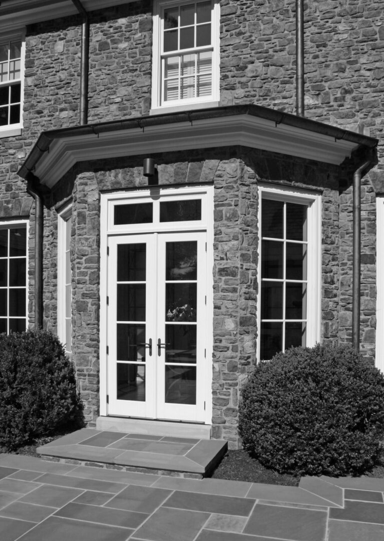 A black and white photo of a building with two doors.