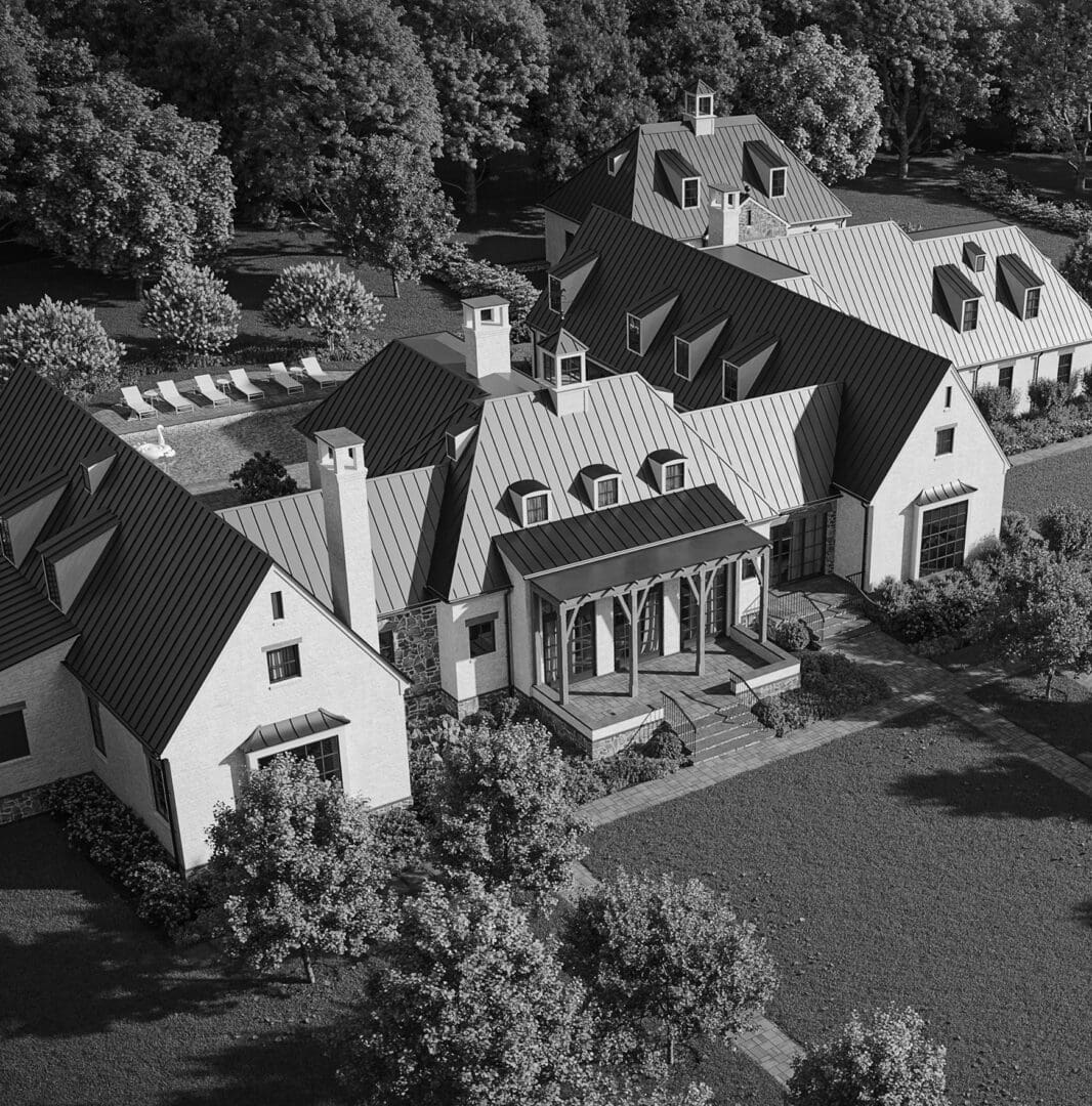 An aerial view of a large house with trees in the background.