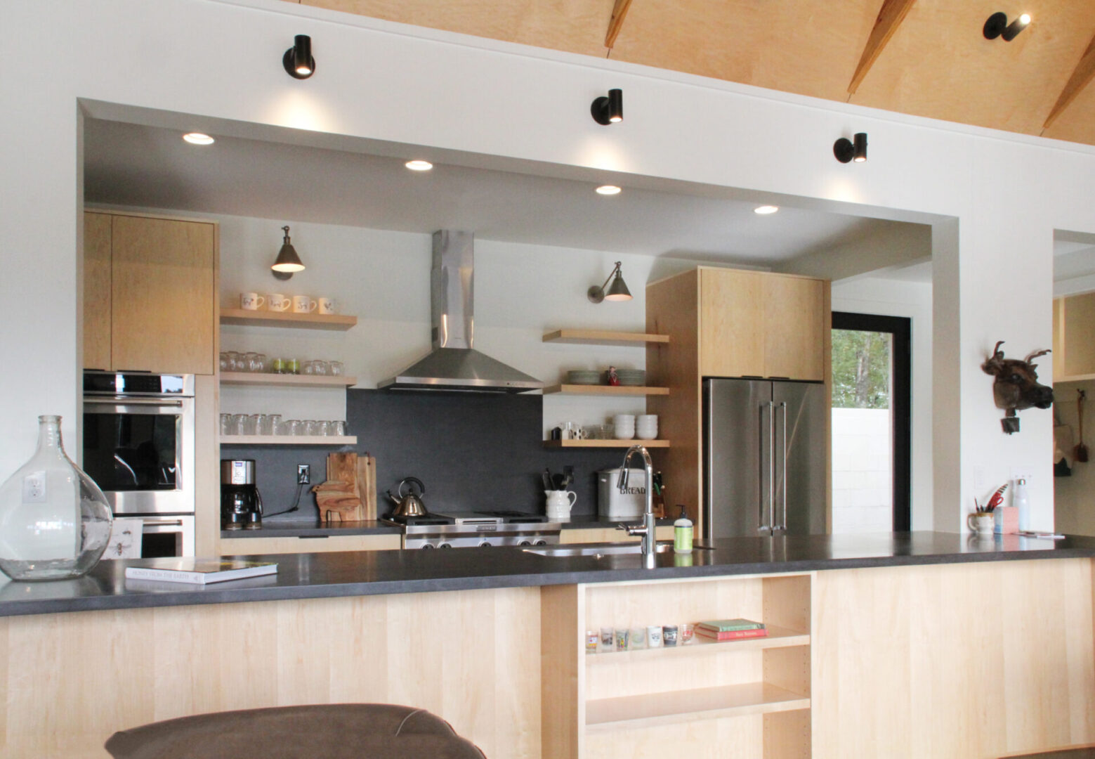 A kitchen with wooden cabinets and black counter tops.