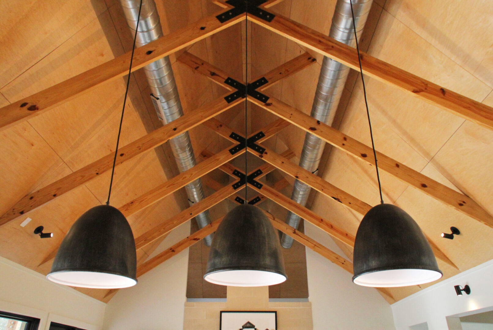 A room with three black lamps hanging from the ceiling.