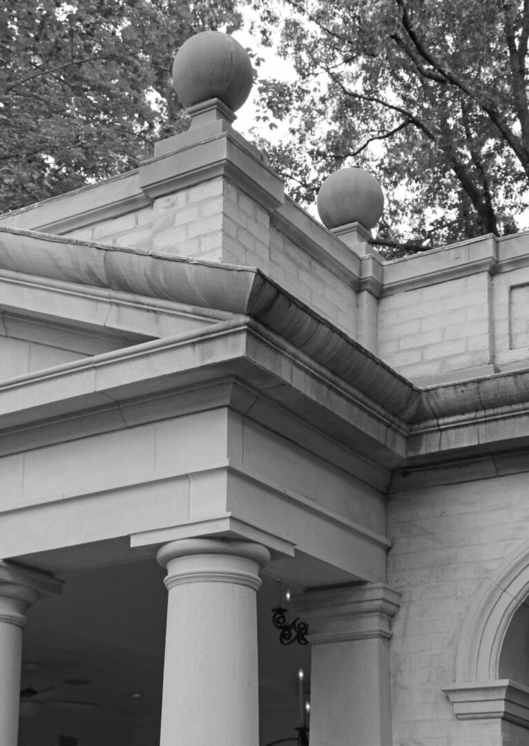 A black and white photo of the corner of an old building.