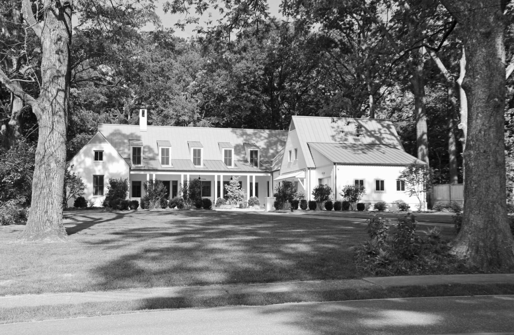 A large white house with trees in the background.