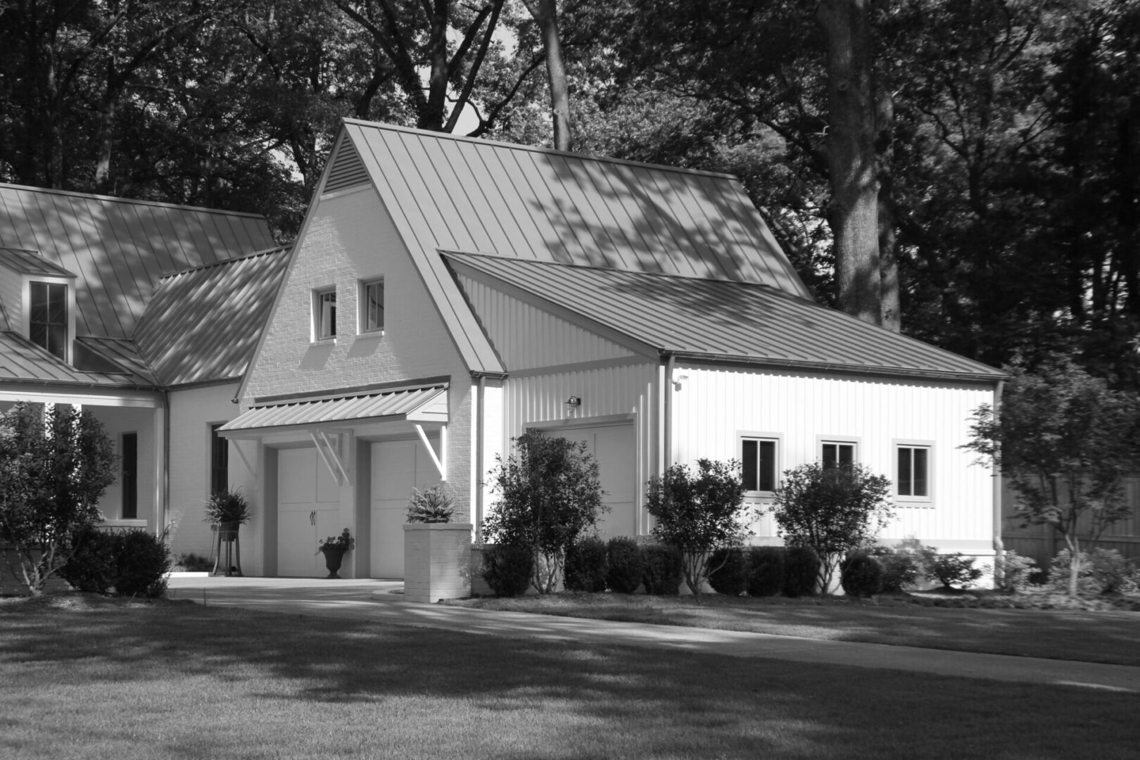 A black and white photo of a house with trees in the background.