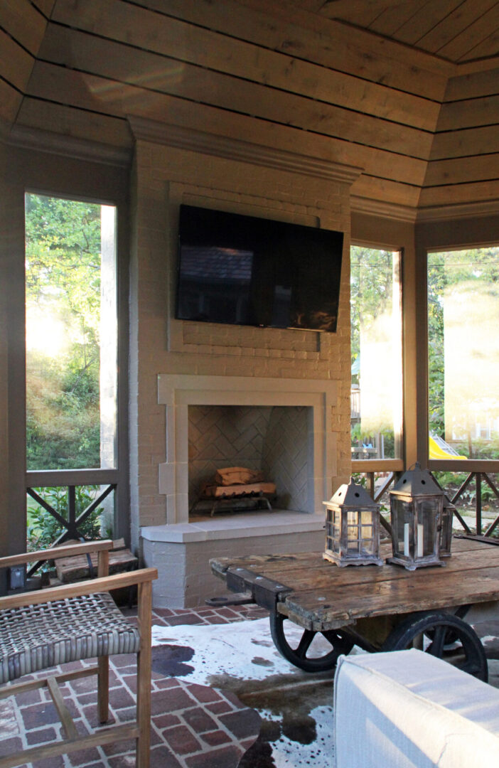 A room with a table and chairs, fireplace and television.