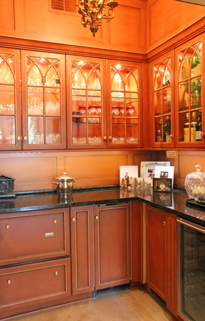 A kitchen with wooden cabinets and glass doors.