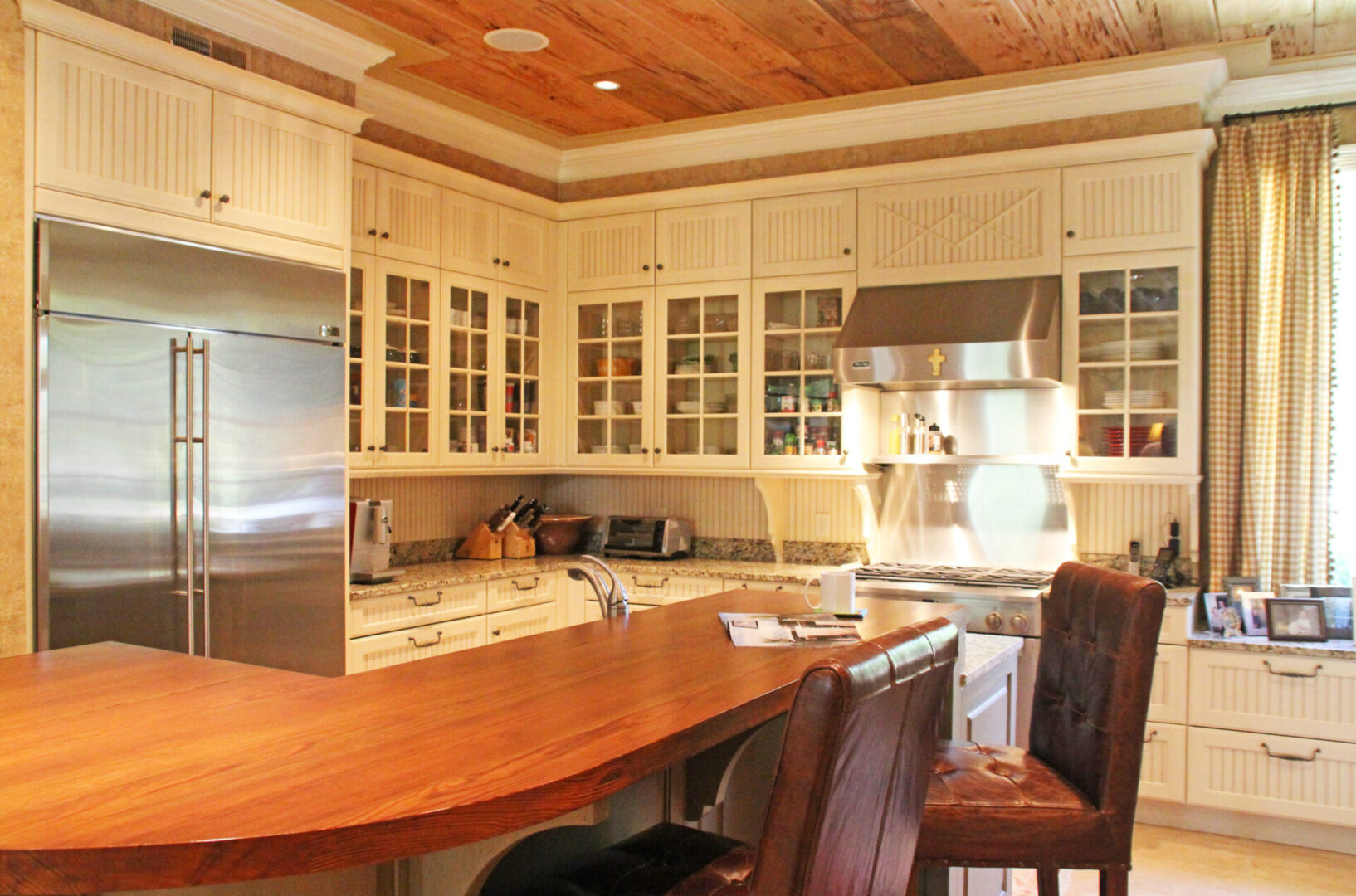 A kitchen with white cabinets and wooden floors.