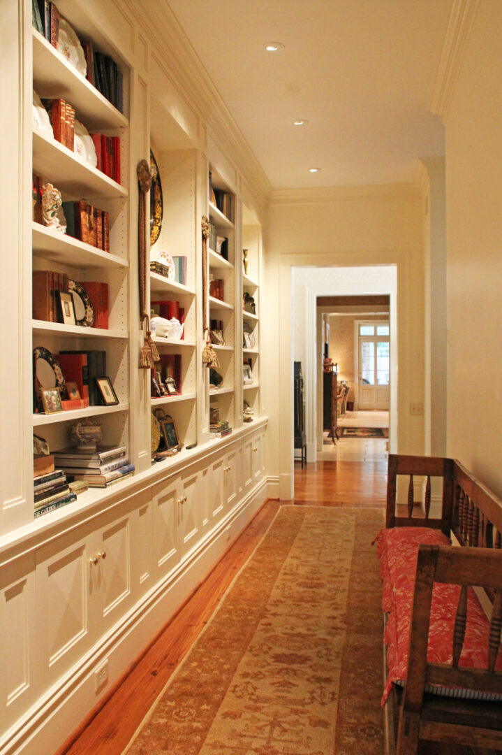 A hallway with bookcases and a bench in the middle.