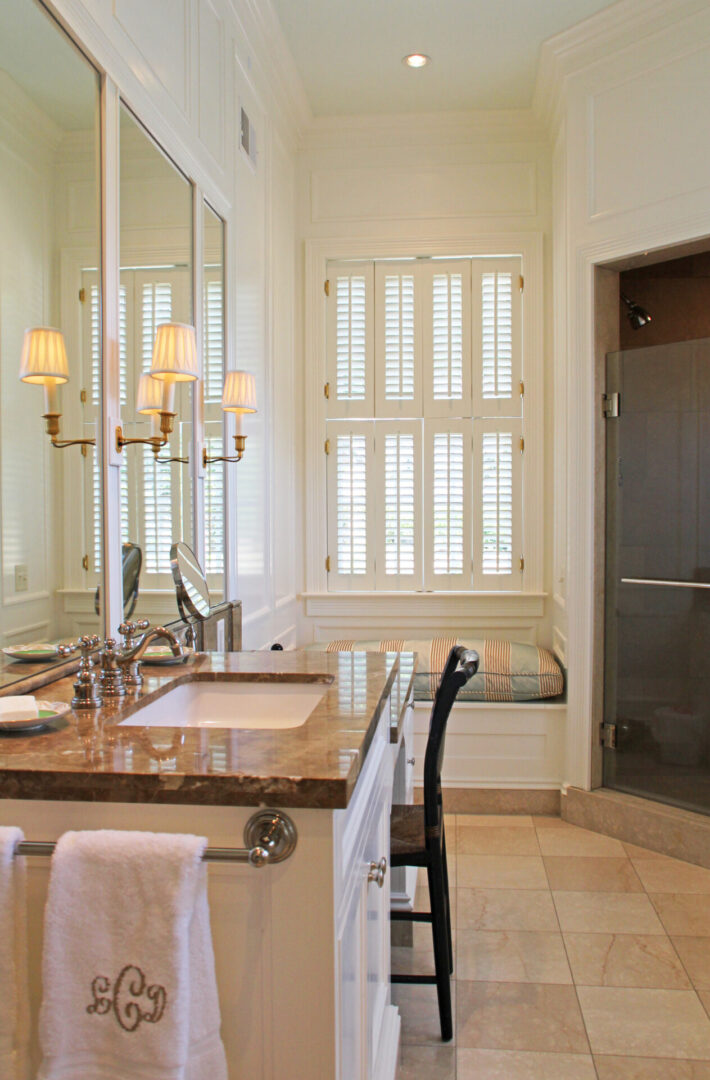 A bathroom with a sink, mirror and window.