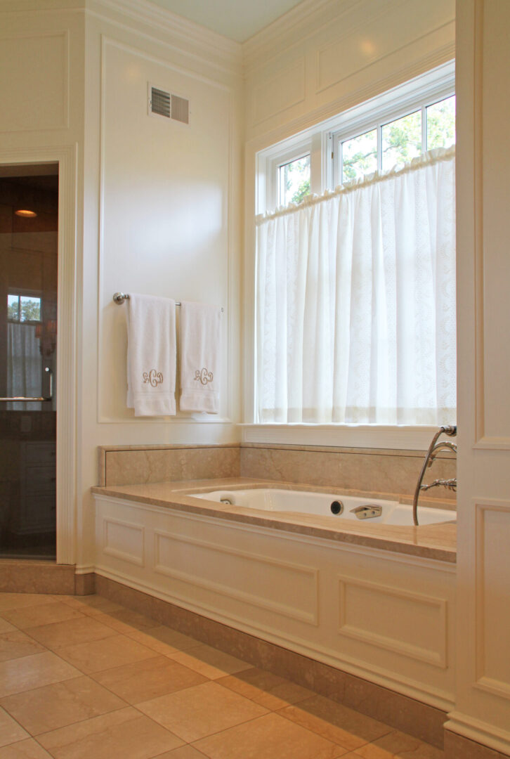 A large bathroom with a tub and window.