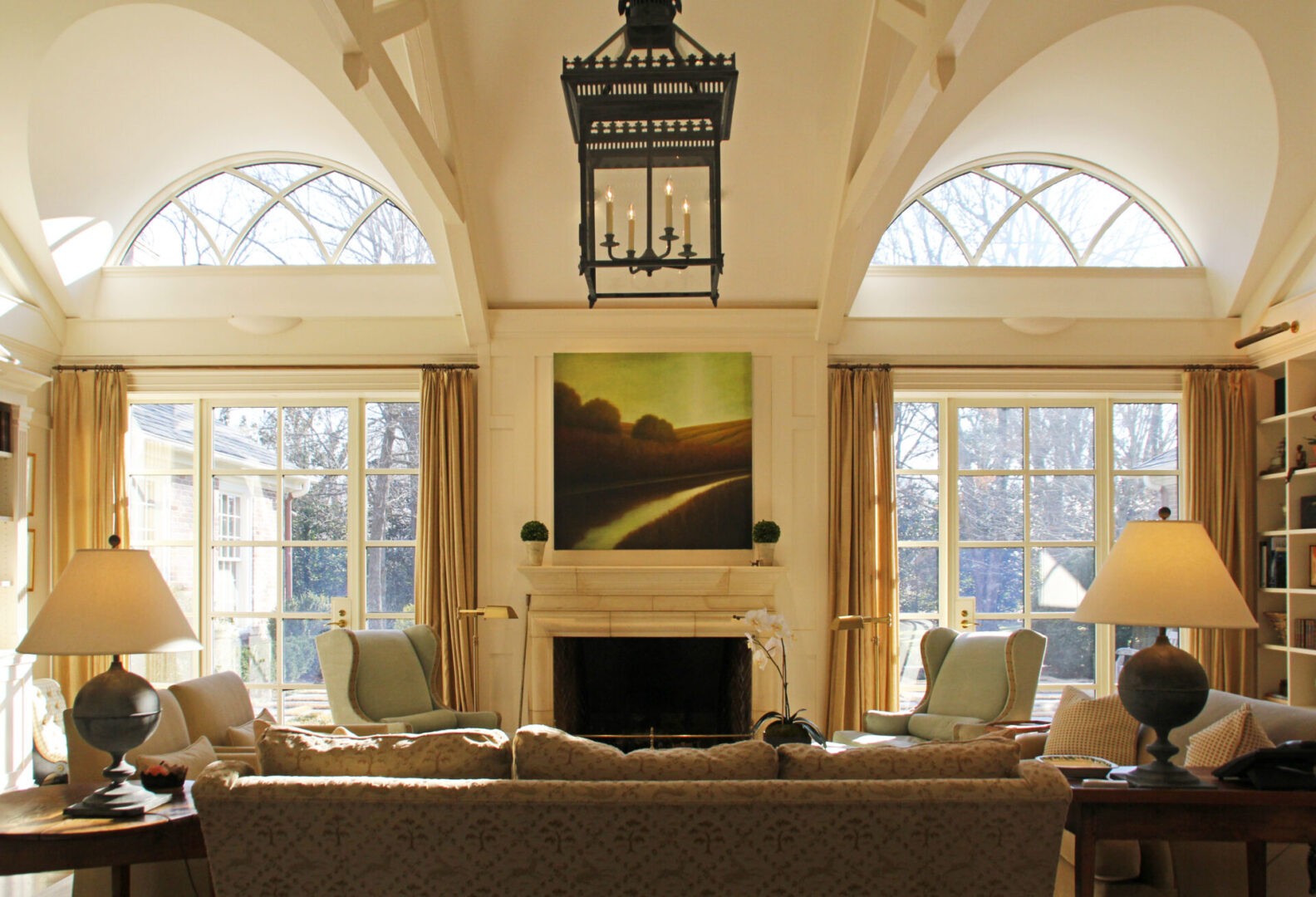 A living room with two large windows and a fireplace.