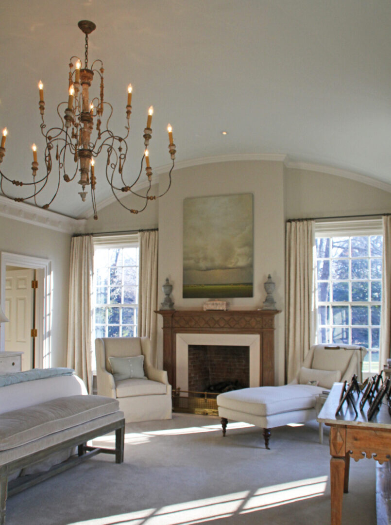 A large bedroom with fireplace and chandelier