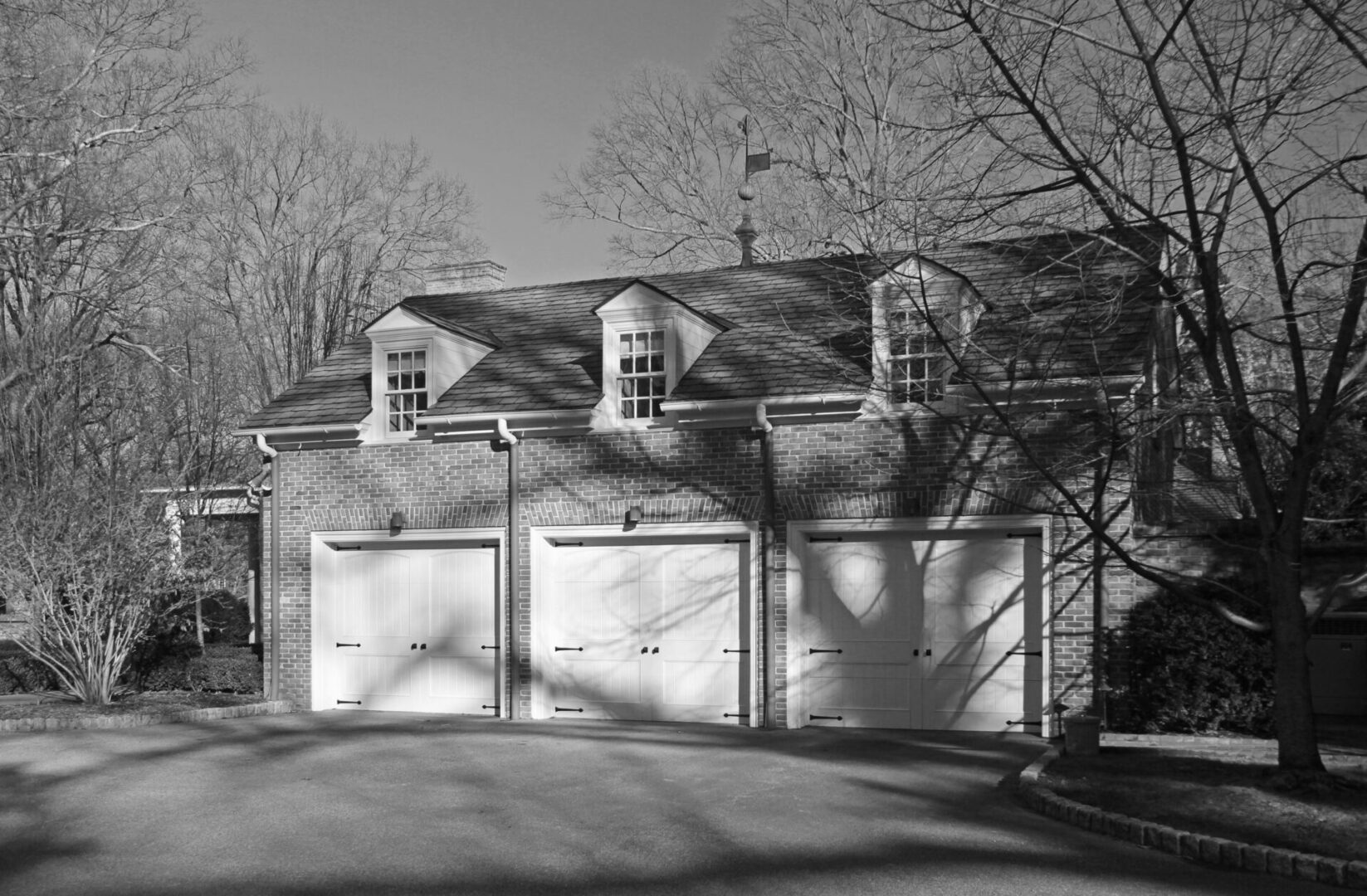 A black and white photo of three garage doors.