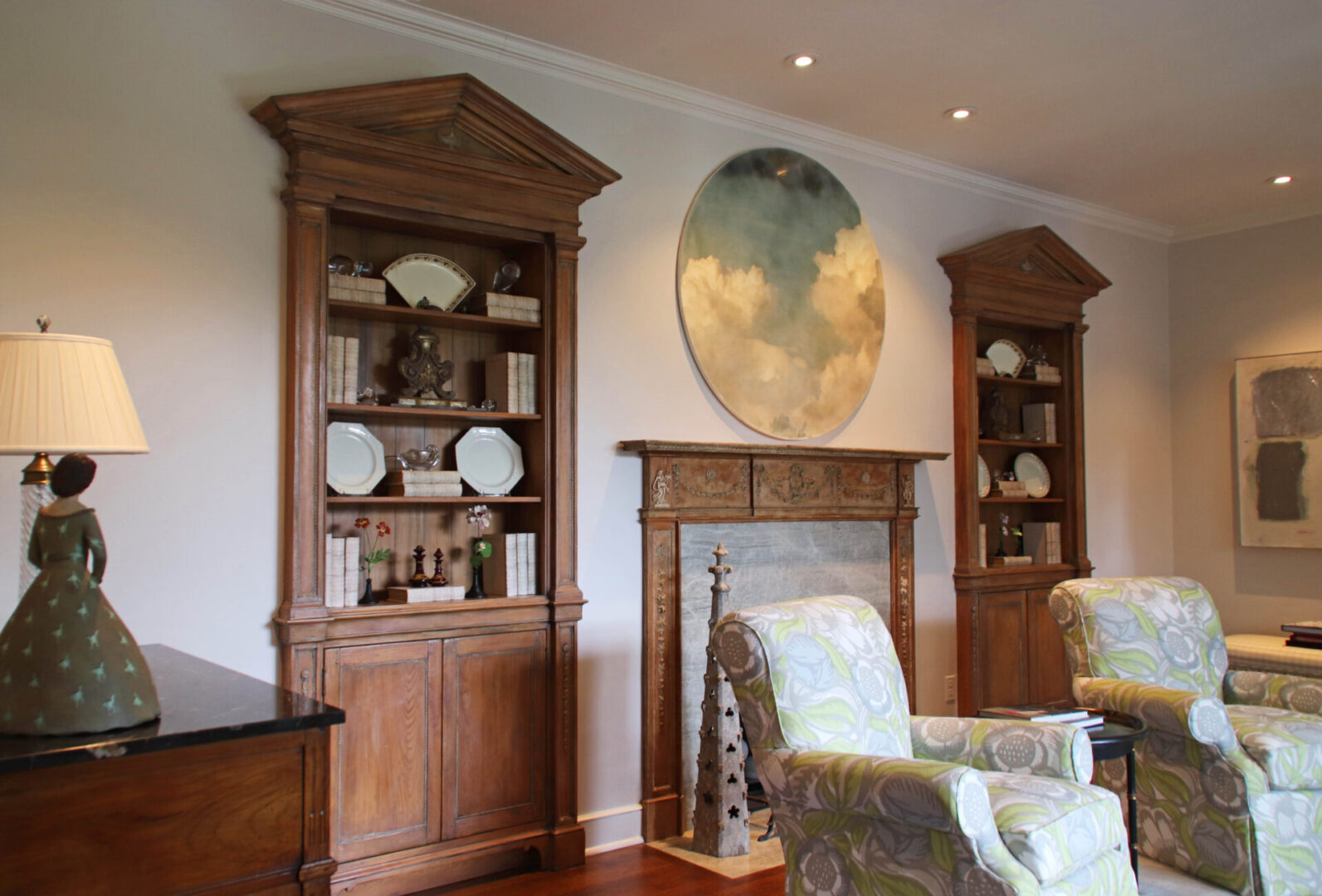 French Provincial living room with two wooden cabinets and a fireplace.