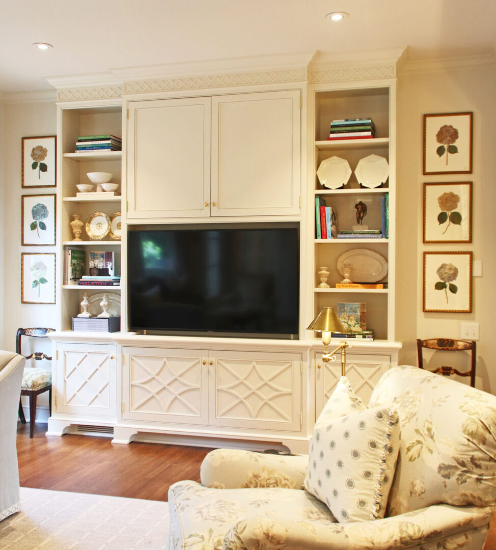 A living room with white furniture and a flat screen tv.