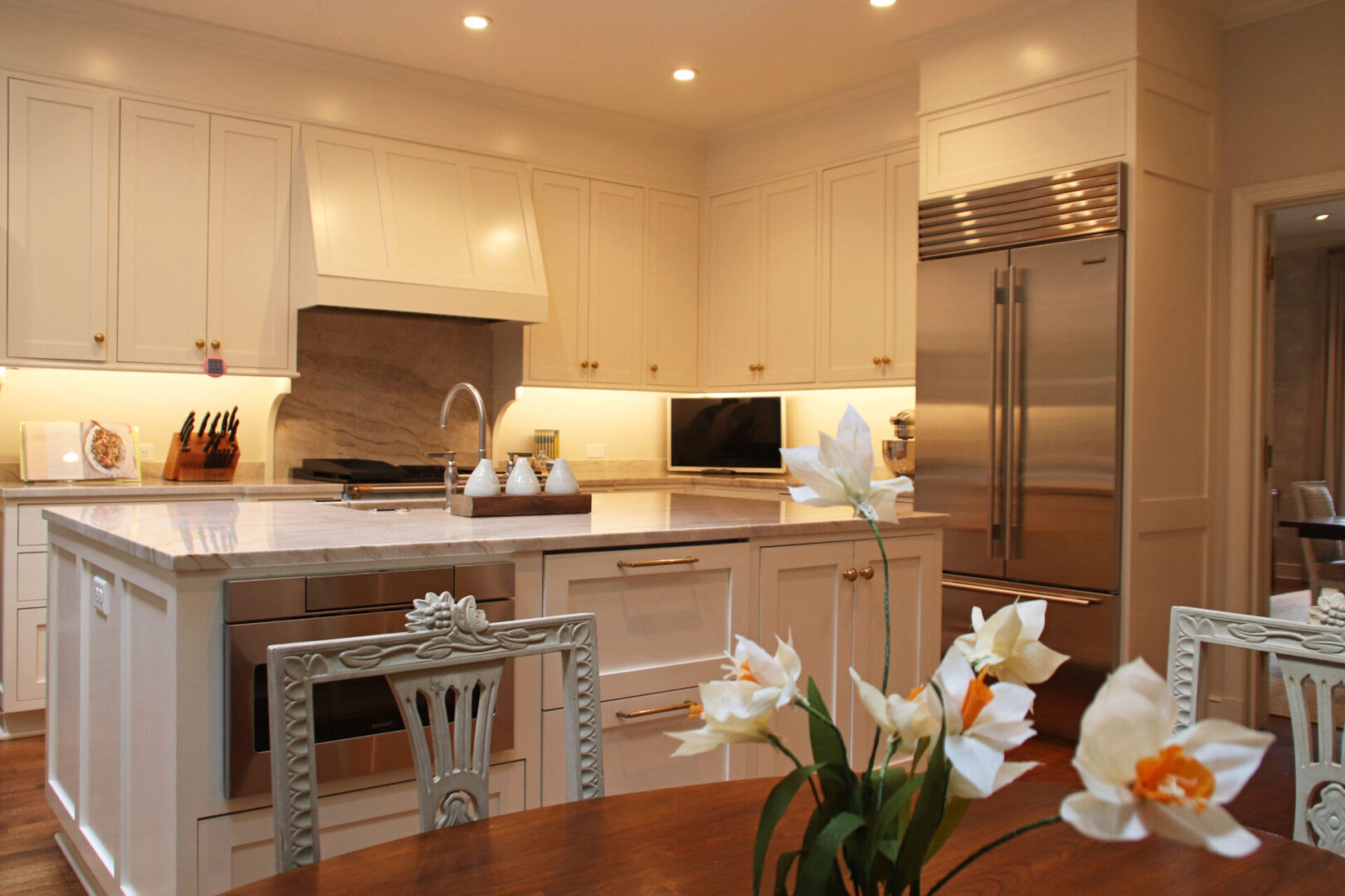 French Provincial kitchen with white cabinets and stainless steel appliances.