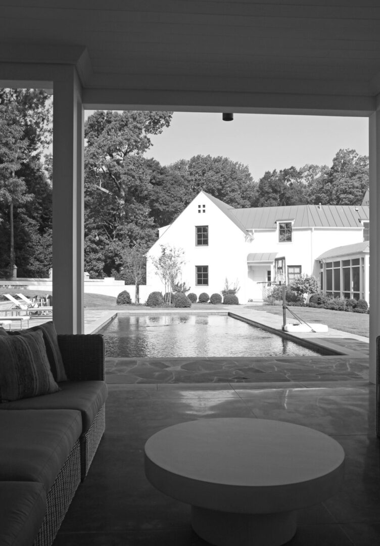 A black and white photo of an outside pool.