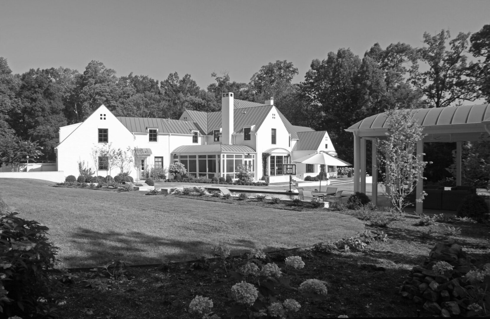 A black and white photo of a house in the country.