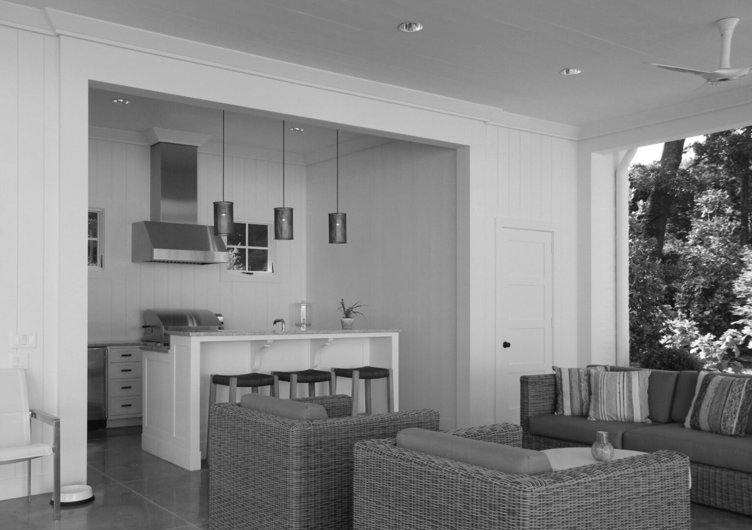 A black and white photo of a living room with couches.