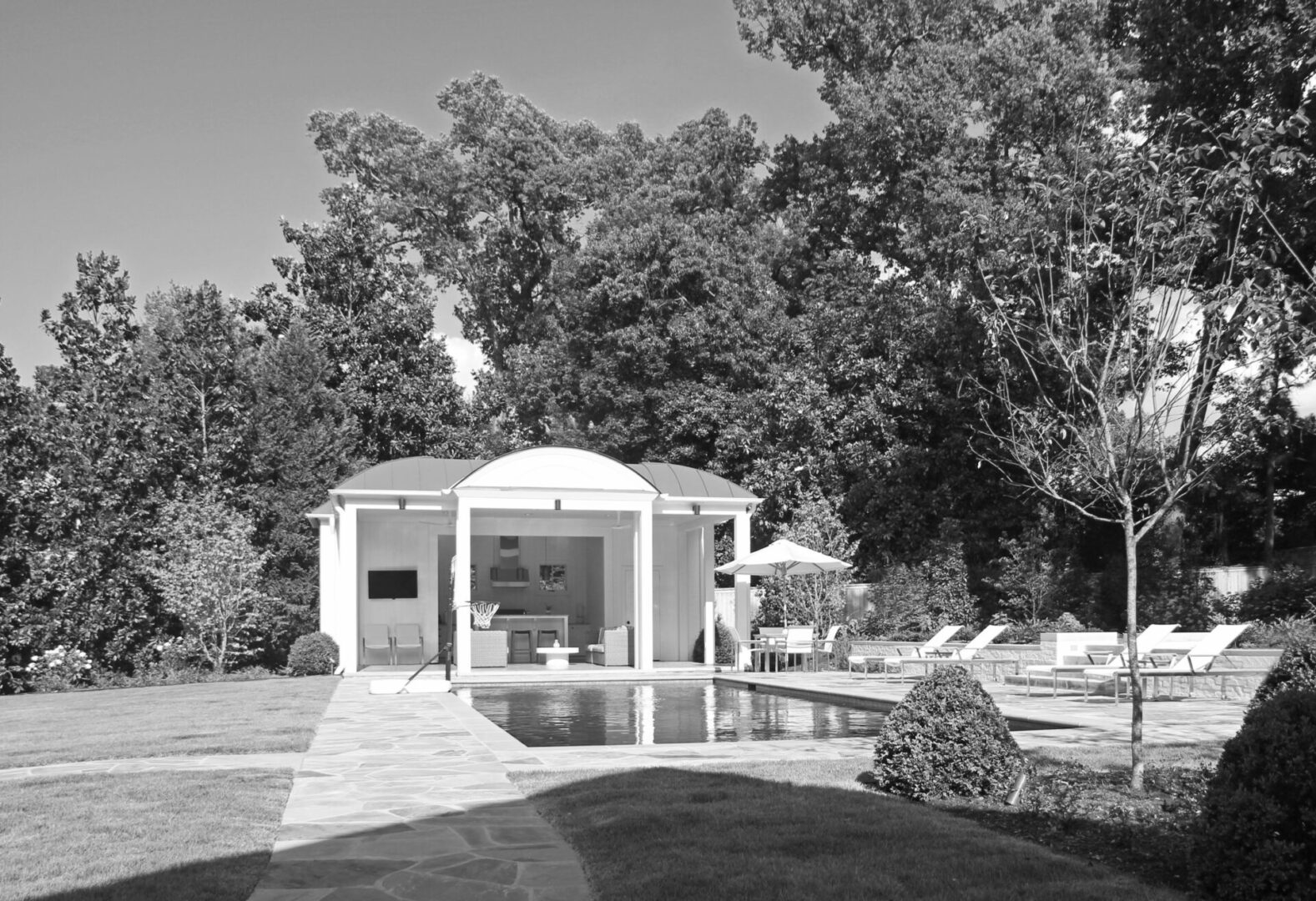 A black and white photo of an outdoor pool.