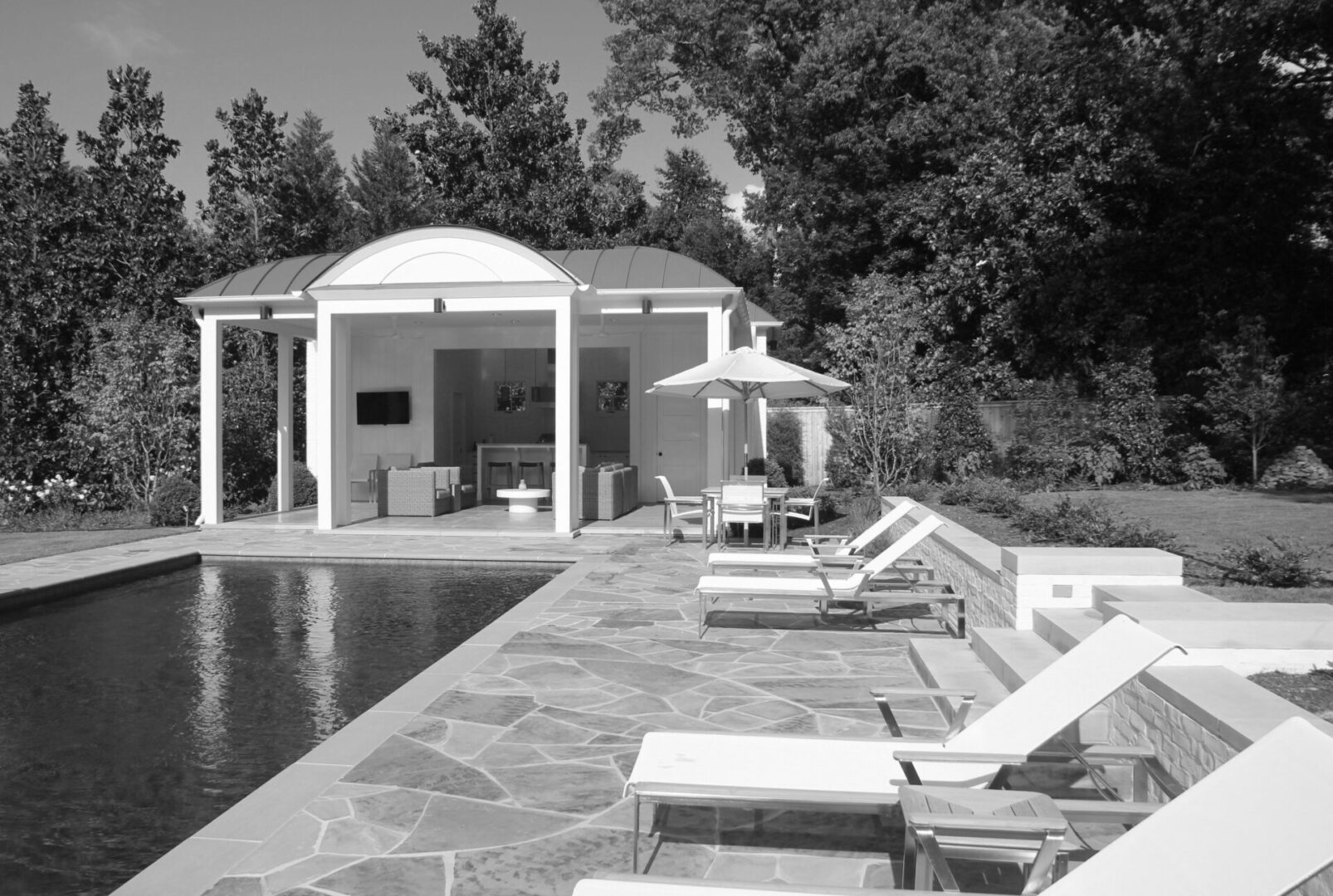 A black and white photo of an outdoor pool.