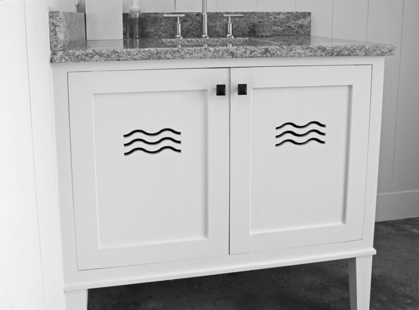 A white cabinet with two wavy lines on the doors.