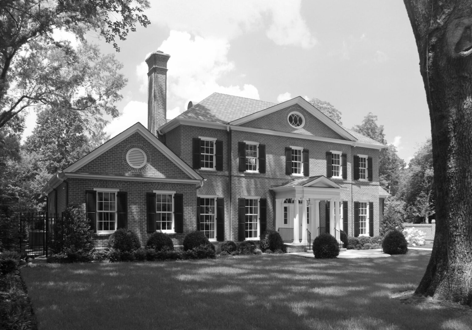 A large brick house with a clock on the front.