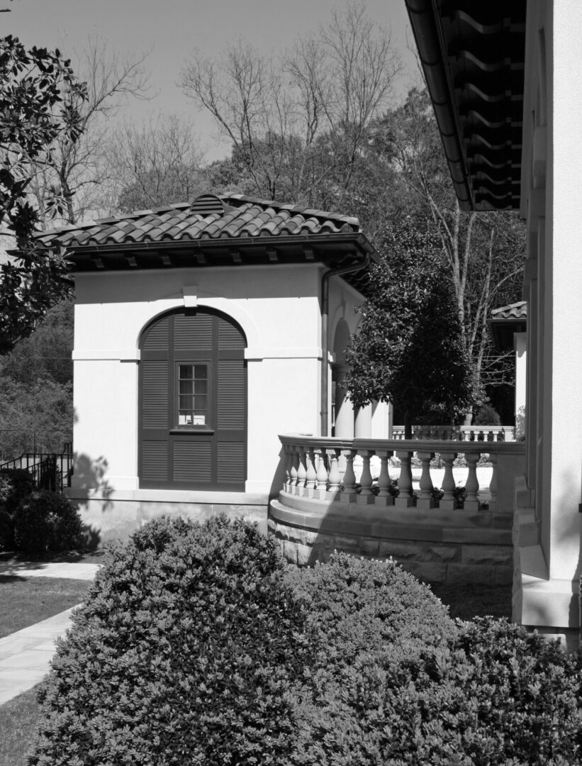 A black and white photo of a building with a balcony.