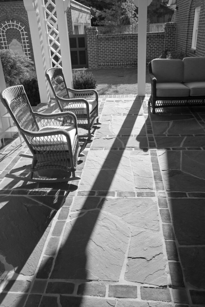 A black and white photo of two rocking chairs on the patio.