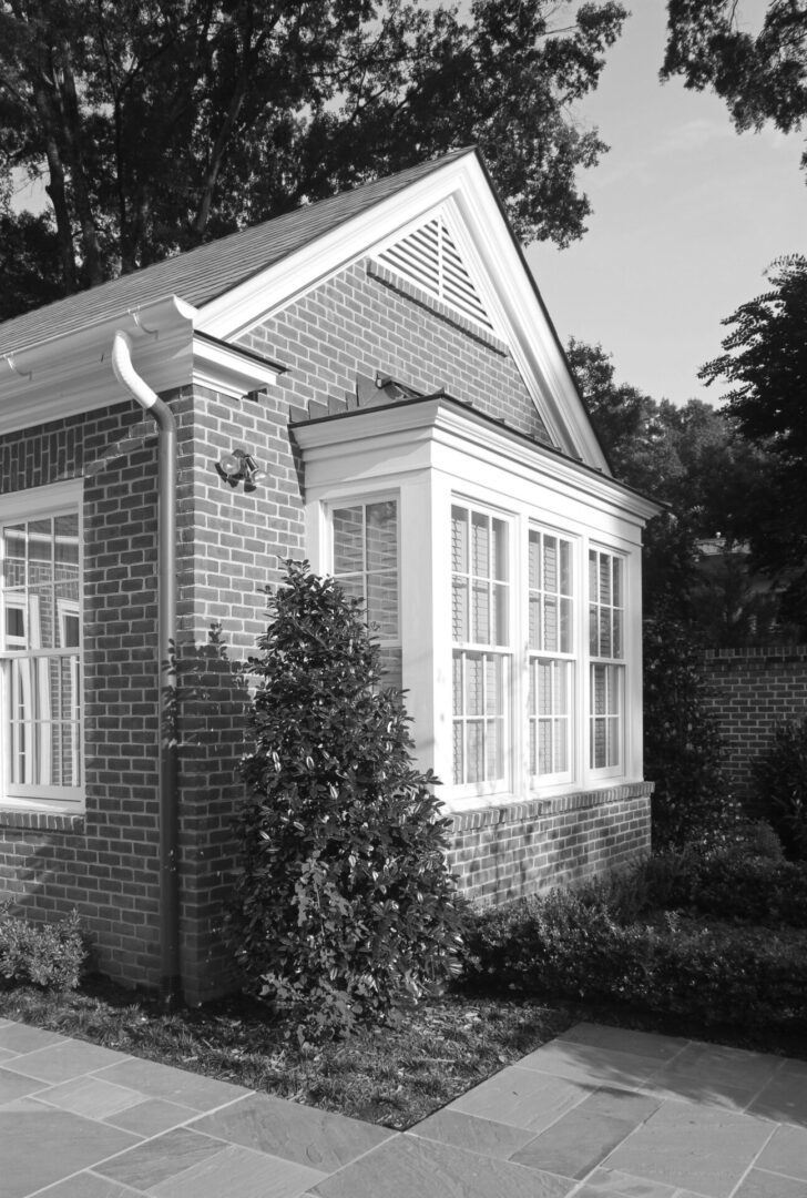 A black and white photo of a house with a garden.