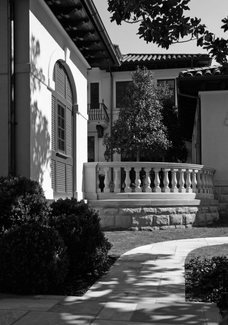 A black and white photo of a building with a balcony.