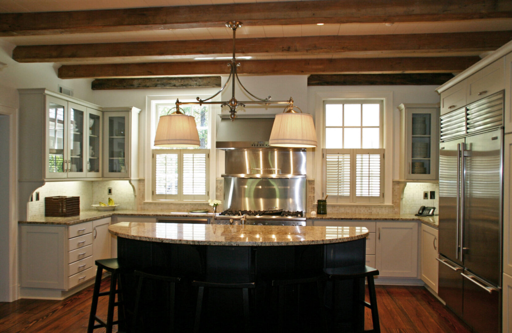 A kitchen with wooden beams and white counters.