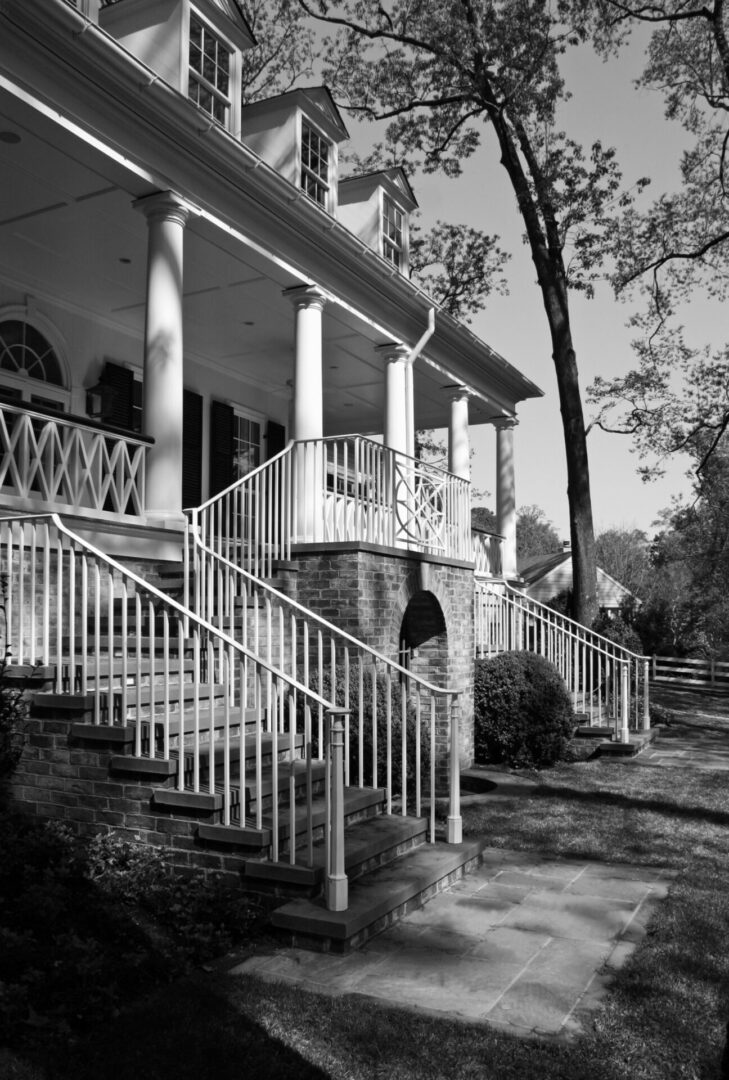 A black and white photo of a house with stairs.