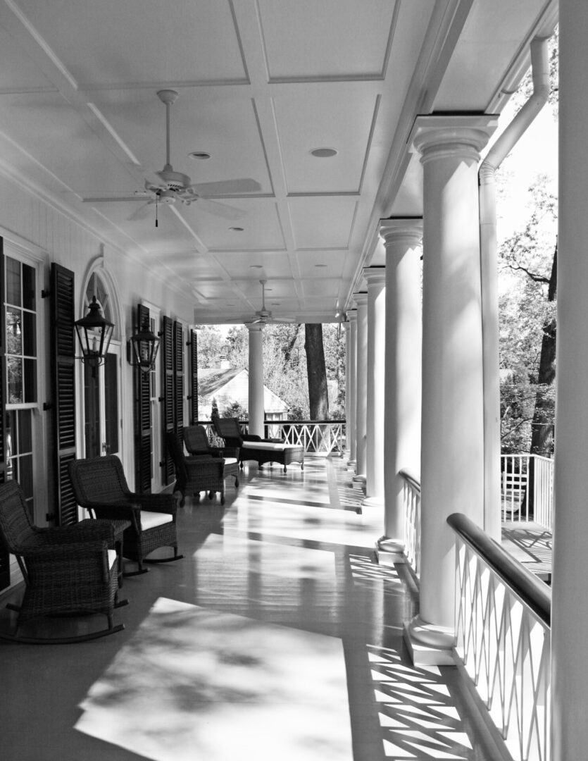 A porch with many chairs and tables in it