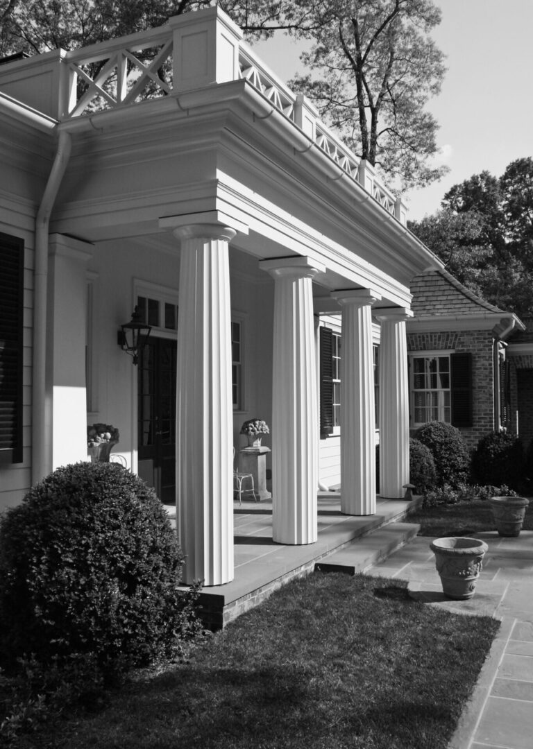 A black and white photo of a house with columns.