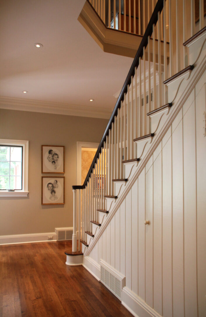 A white staircase with black handrails and wooden steps.