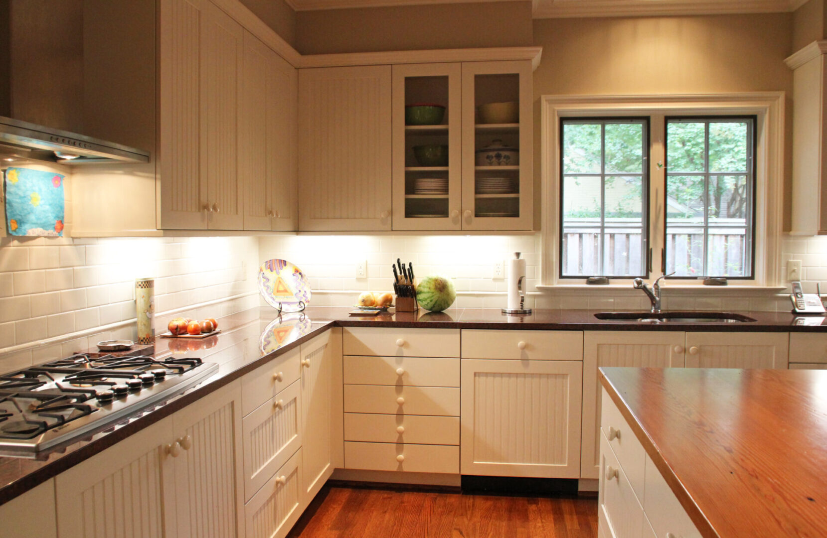 A kitchen with white cabinets and black counter tops.