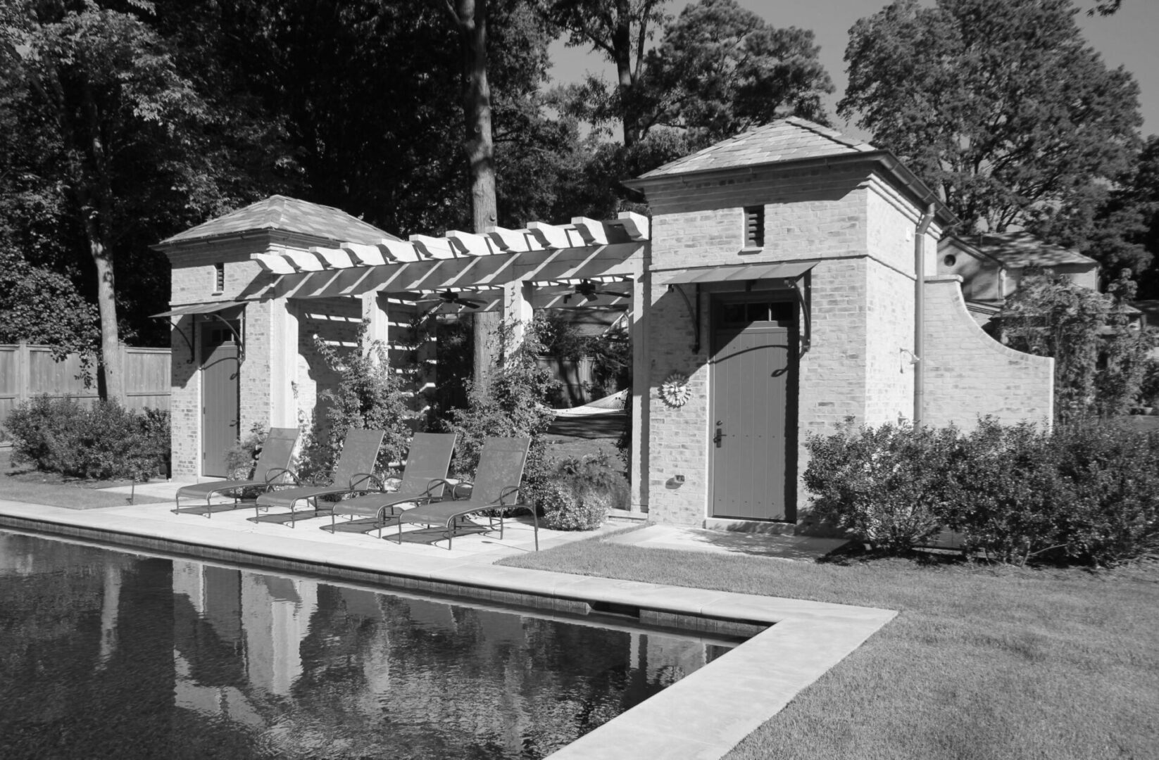 A black and white photo of an outdoor pool.