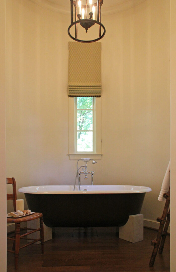 A bath tub sitting under a window in the bathroom.