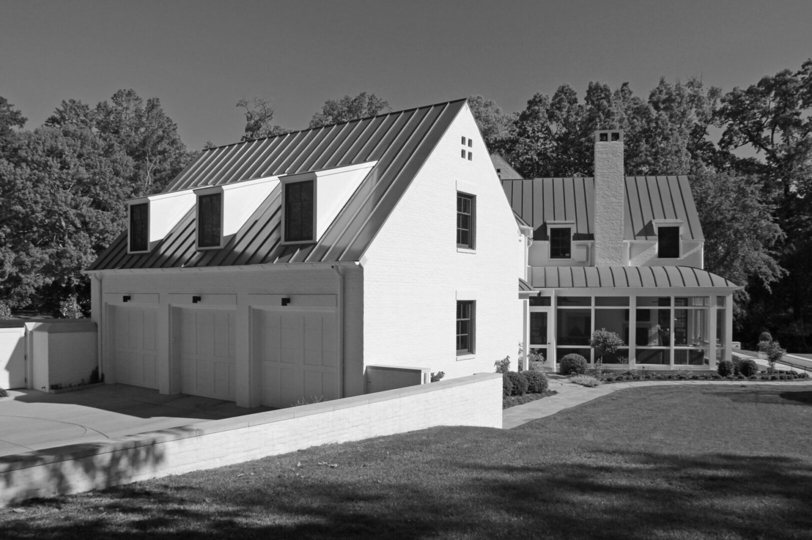 A black and white photo of a house with a fence.