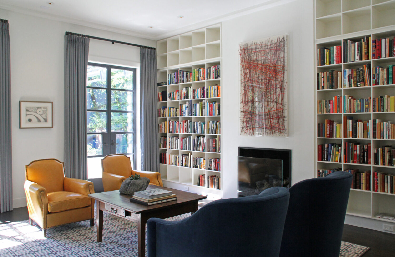 A living room with a fireplace and bookshelves