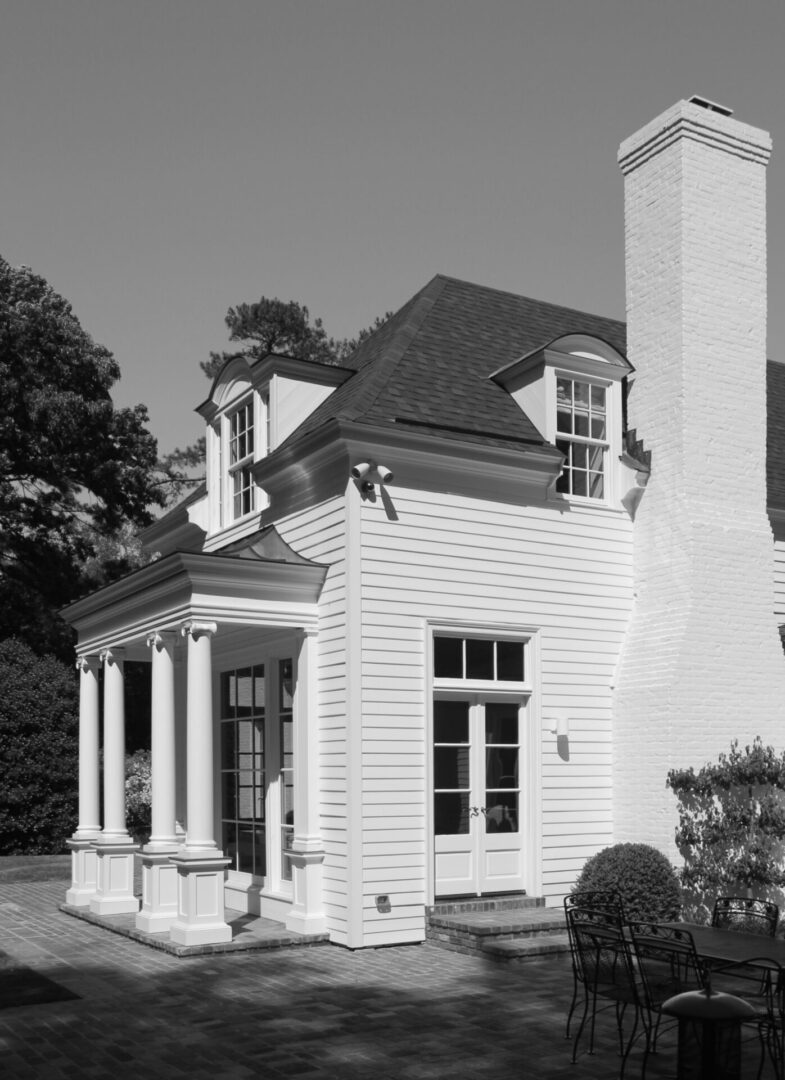 A black and white photo of a house with a tall tower.