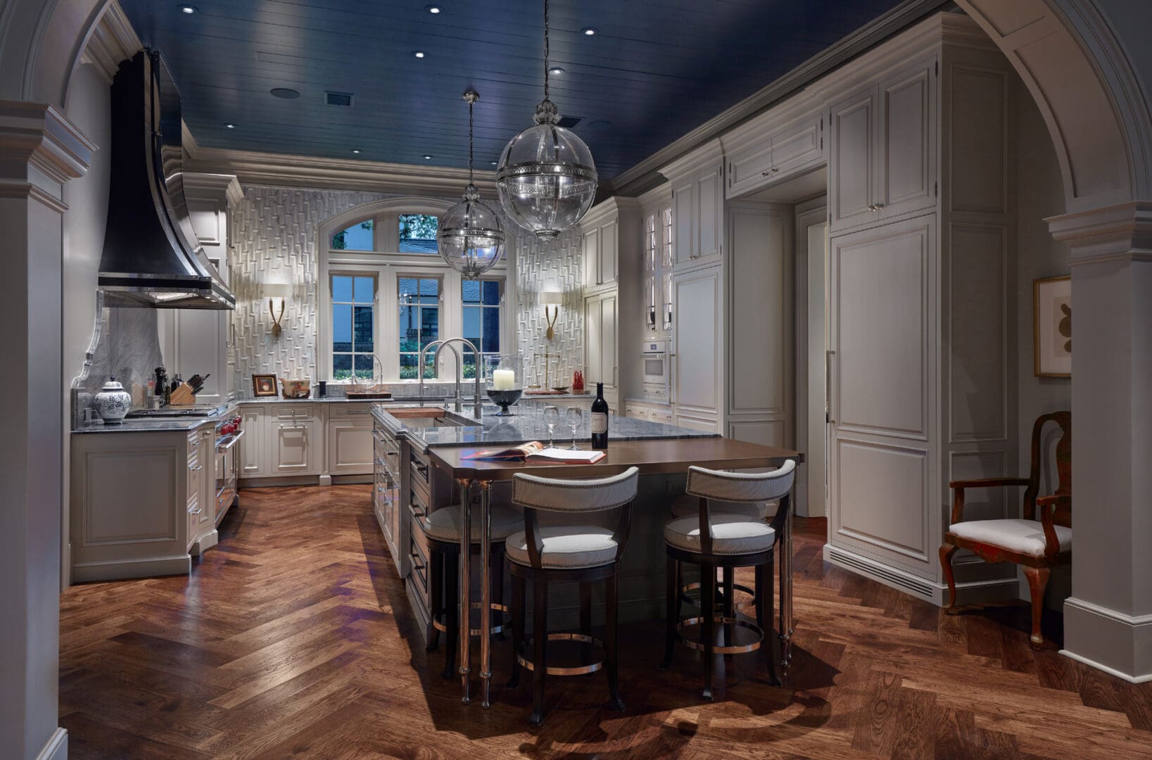 A kitchen with a large island and wooden floors.